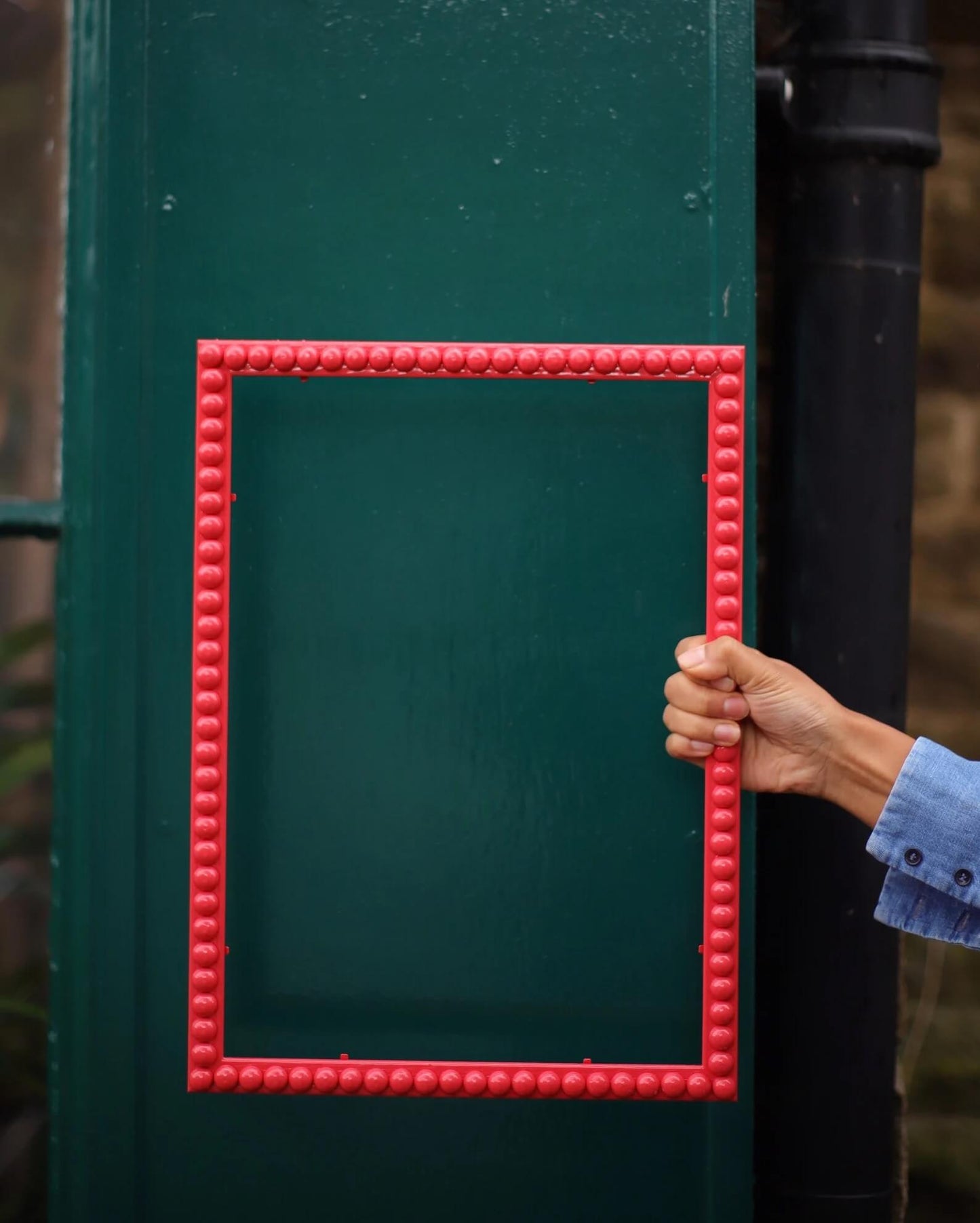 Hand holding a Raspberry Bobbin Frame