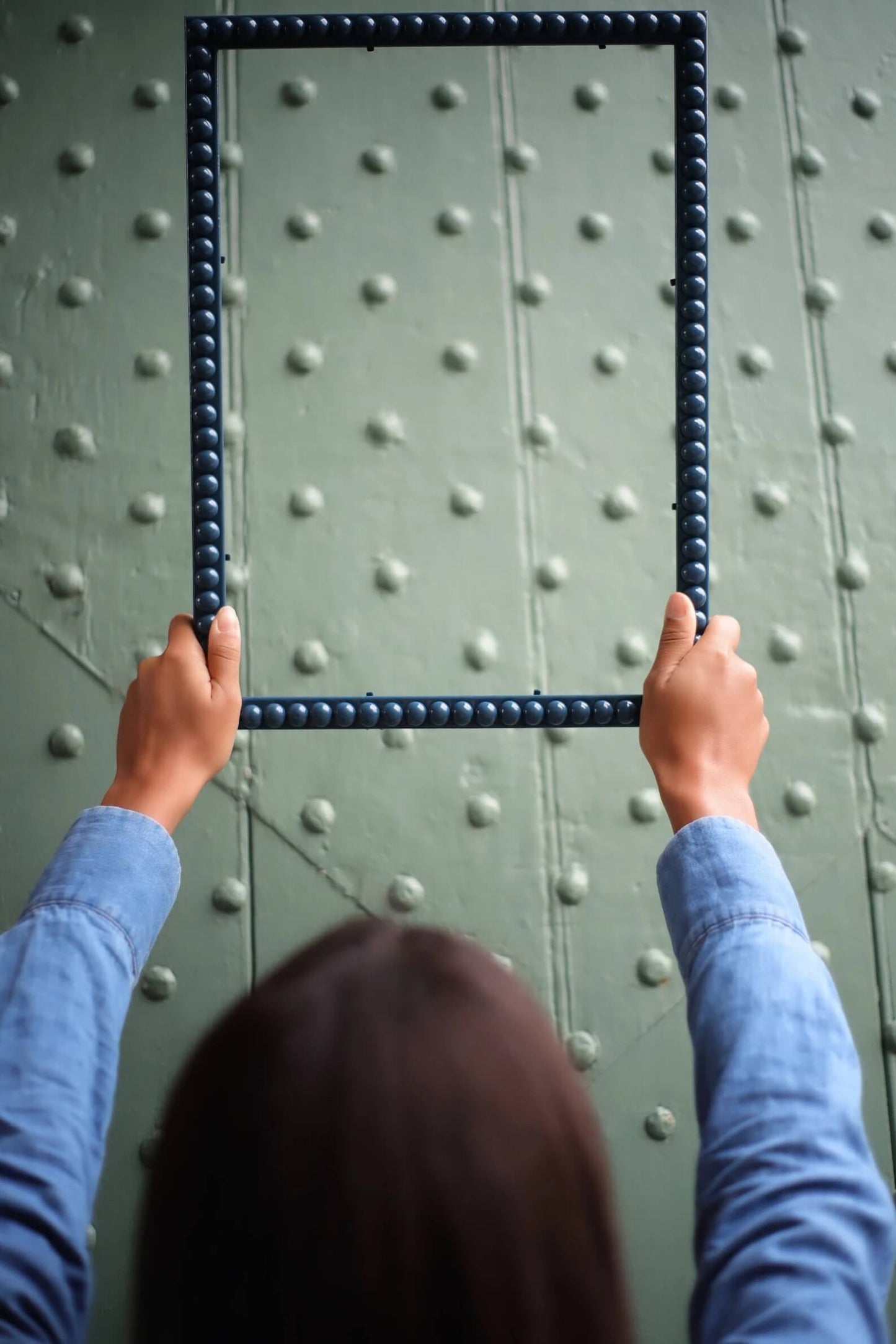 Hands holding an Inky Blue Bobbin Frame