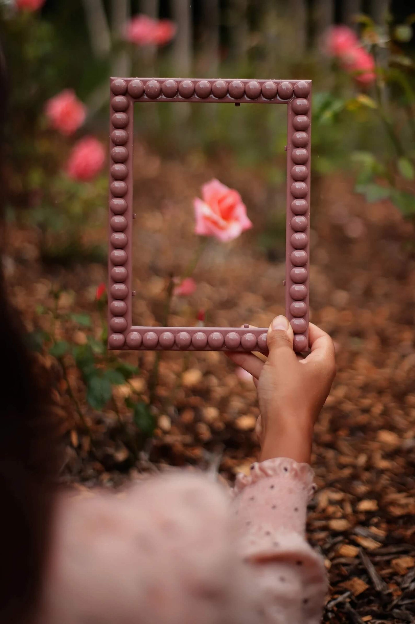Hand holding Dusty Rose Bobbin Frame